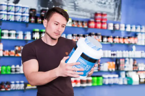 Deportista mirando etiquetado de suplementos